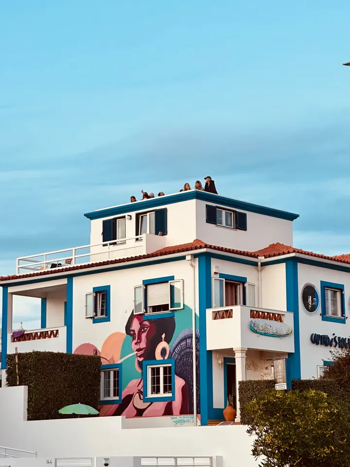 Captain's Log House exterior at dusk with the painted mural and rooftop terrace
