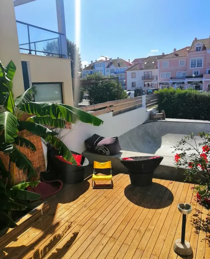 Sunlit wooden terrace with banana plants and lounge seating